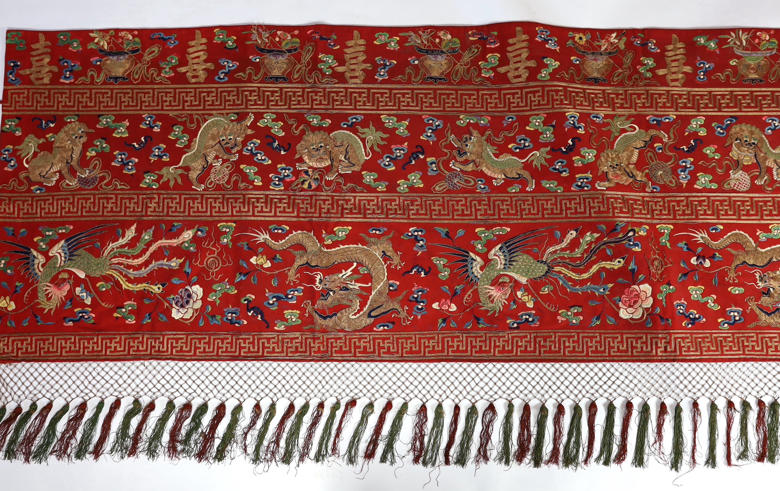 A Chinese embroidered silk ‘dragon, phoenix and lion’ panel or table frontal, late Qing dynasty, 117cm x 337cm